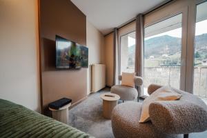 a room with a couch and chairs and a large window at Studio Arclusaz by ExplorHome in Albertville