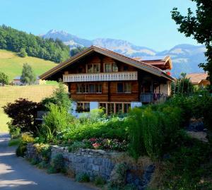 ein Holzhaus auf einem Hügel mit Garten in der Unterkunft Chalet Ried Naturpark Diemtigtal in Diemtigen