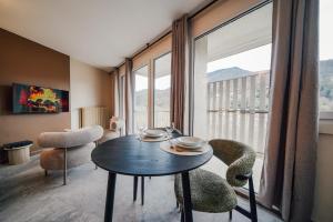 a room with a table and chairs and a large window at Studio Arclusaz by ExplorHome in Albertville
