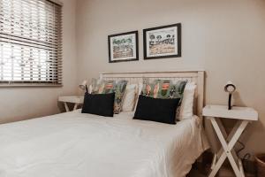 a bedroom with a white bed with two pillows at Bona Vista in Pringle Bay