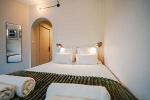a bedroom with a bed with white sheets and pillows at Studio Arclusaz by ExplorHome in Albertville