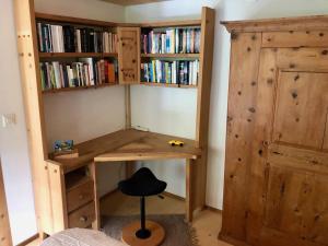 ein Zimmer mit einem Schreibtisch und einem Bücherregal in der Unterkunft Chalet Ried Naturpark Diemtigtal in Diemtigen