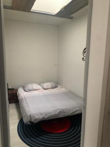 a small bedroom with a bed on a rug at Marieno in Barbâtre