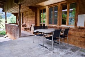 eine Terrasse mit Tisch und Stühlen an einem Haus in der Unterkunft Chalet Ried Naturpark Diemtigtal in Diemtigen