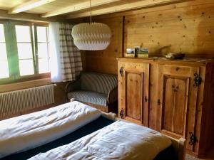ein Schlafzimmer mit einem Bett, einem Schrank und einem Fenster in der Unterkunft Chalet Ried Naturpark Diemtigtal in Diemtigen
