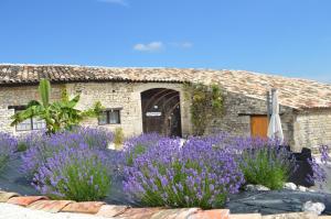 a garden with purple flowers in front of a building at Gîte Manoir in Bouloc