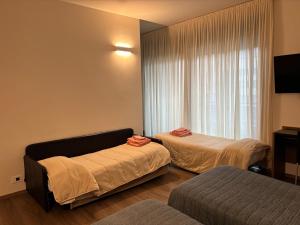 a hotel room with two beds and a window at Albergo Valle d'Oro in Albino +81 photos