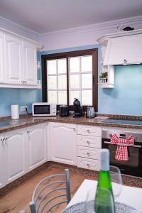 a kitchen with white cabinets and a stove top oven at El Hierro Bed in Valverde