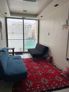 a living room with a couch and a red rug at House of Nomads - Hostel in Muscat