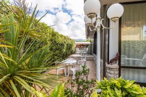 a patio with tables and chairs and plants at Hotel Matilde in Marina di Massa
