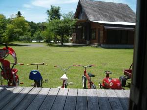 a group of bikes parked on the grass in front of a house at Guesthouse Coco Garage in Kirishima