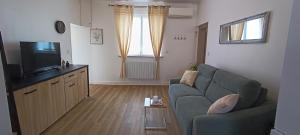a living room with a couch and a television at Le Havre de Sauge in Imphy