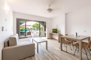 a living room with a table and a dining room at Aparthotel Puerto Cala Vadella in Cala Vadella