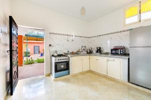 a kitchen with a stove and a refrigerator at Private Villa with Pool and Hammam Marrakech in Oulad Akkou