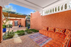 an orange couch is sitting on a patio at Private Villa with Pool and Hammam Marrakech in Oulad Akkou