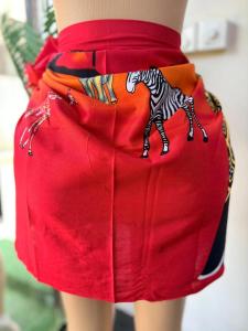 a woman wearing a red skirt with a zebra painted on it at Mabegi african Designs in Arusha
