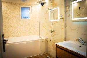 a bathroom with a tub and a sink and a shower at Le 8 Suite Spa Privative Sauna et Jacuzzi parking gratuit in Mâcon +21 photos