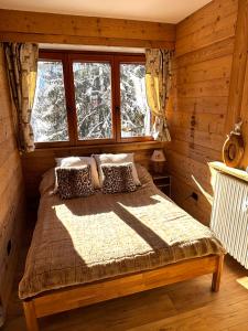 a bedroom with a bed in a log cabin at Studio Piccola Renna in Limone Piemonte