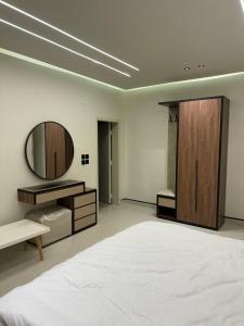 a bedroom with a large bed and a mirror at شقة مشراق in Al-ʿUla