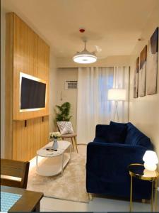 a living room with a blue couch and a table at JB Casa del Alivio in Butuan