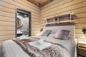 a bedroom with a large bed with towels on it at Bimmel Arctic Suite by PolarVillas in Kittilä
