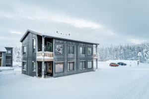 a house in the snow with a car parked at Bimmel Arctic Suite by PolarVillas in Kittilä