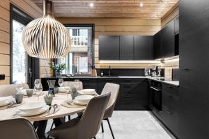 a kitchen with a table with chairs and a chandelier at Bimmel Arctic Suite by PolarVillas in Kittilä