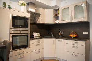 a kitchen with white cabinets and a black counter top at Rosaliya in Cochem