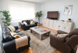 a living room with couches and a flat screen tv at Tres Coronas in Olite