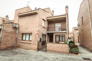 a brick building with a balcony on the side of it at Tres Coronas in Olite