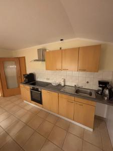 a kitchen with wooden cabinets and a sink in it at Ferienwohnung Gaber in Reichshof  +5 photos