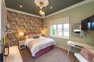 a bedroom with a bed with a floral wallpaper at The Station at Shustoke - Birmingham Airport & NEC in Shustoke