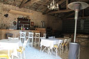a restaurant with white tables and chairs and a bar at Gîte Manoir in Bouloc