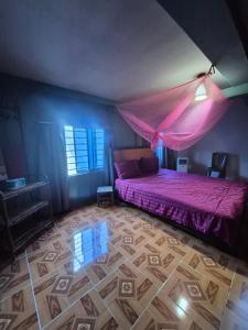 a bedroom with a purple bed with a pink mosquito net at Vagabonds in Kaôh Rŭng (3)