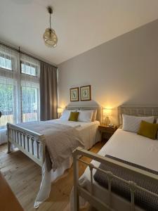 a bedroom with two beds and a window at Porta E Gjelbër in Përmet