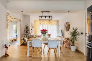 a dining room and living room with a table and chairs at O Lar de Laura Casa familiar para escapada tranquila con piscina y sala de juegos cerca de Vigo in Vigo