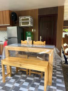 a table with a wooden bench in a kitchen at Gavins Nest in Romblon