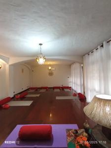 a living room with a large room with red pillows and a table at Casa Quarto 1 in Jaraguá do Sul
