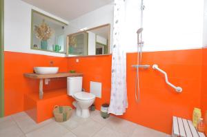 an orange bathroom with a toilet and a sink at VILLA LES SALINES Maison de Vacances au Grau du Roi in Le Grau-du-Roi +66 photos