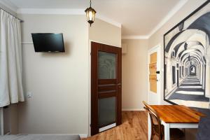 a room with a table and a tv on a wall at APARTAMENT 16 in Zamość