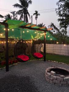 a pergola with lights and a fire pit at Modern Thatch in Phú Nhuận
