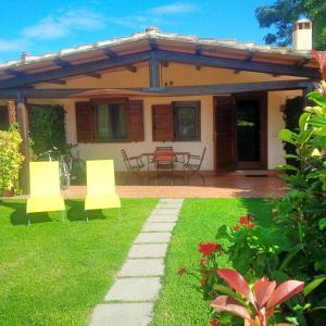 a house with two chairs and a table in the yard at Podere Oca Bianca in Pescia Romana