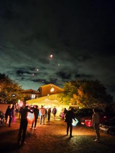 a group of people standing in a parking lot at night at La Bergerie in Pollionnay