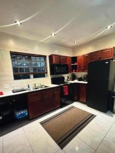 a kitchen with wooden cabinets and a black refrigerator at Escape to paradise in Providenciales +1 photo