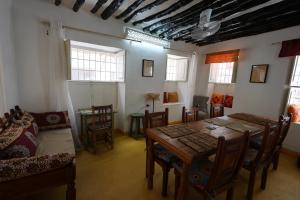 a dining room with a table and chairs at NOMAD Hostel Stone Town in Zanzibar City