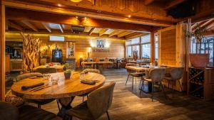 a restaurant with wooden walls and tables and chairs at Hôtel - Restaurant Le Couchetat in La Bresse