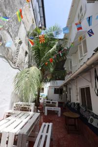 a patio with picnic tables and flags on a building at NOMAD Hostel Stone Town in Zanzibar City