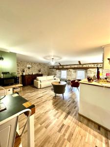 a large kitchen and living room with a table at La Pastourelle en Lozère in Le Bacon +38 photos