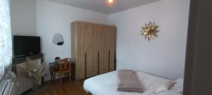 a bedroom with a bed and a wooden cabinet at Le Havre de Sauge in Imphy