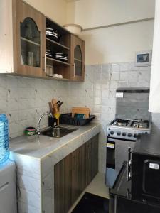 a kitchen with a sink and a stove at Khalisee homes studio apartment 5 in Voi